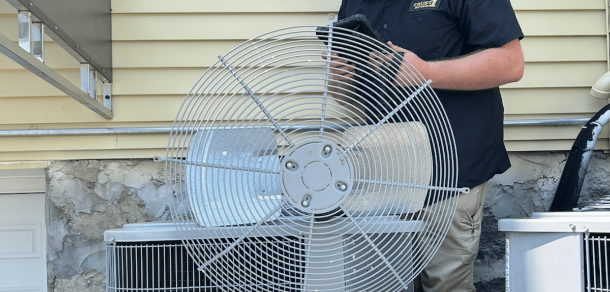 Trust 1 technician servicing an outdoor AC condenser fan