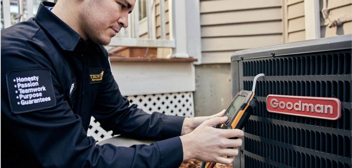 Trust 1 technician checking refrigerant pressures on an outdoor heat pump
