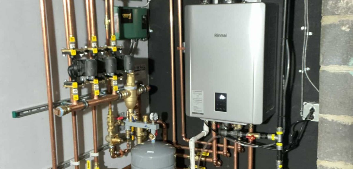 Wall-mounted Rinnai hot water boiler with copper zone piping, circulator pumps and expansion tank installed by Trust 1