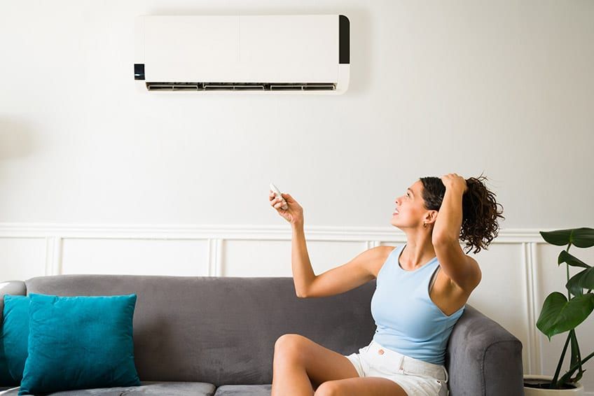 Person fanning herself in front of AC unit
