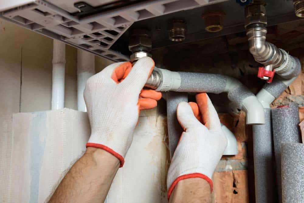 Insulated water heater by expert with hand wearing gloves