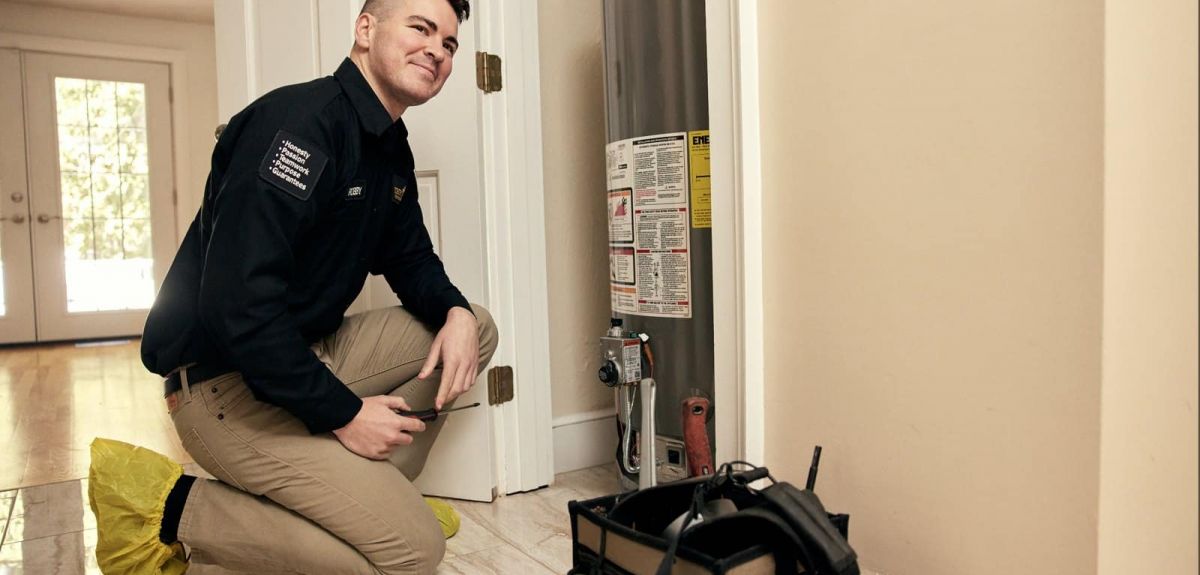 Trust 1 technician repairing a Rheem gas water heater in a home